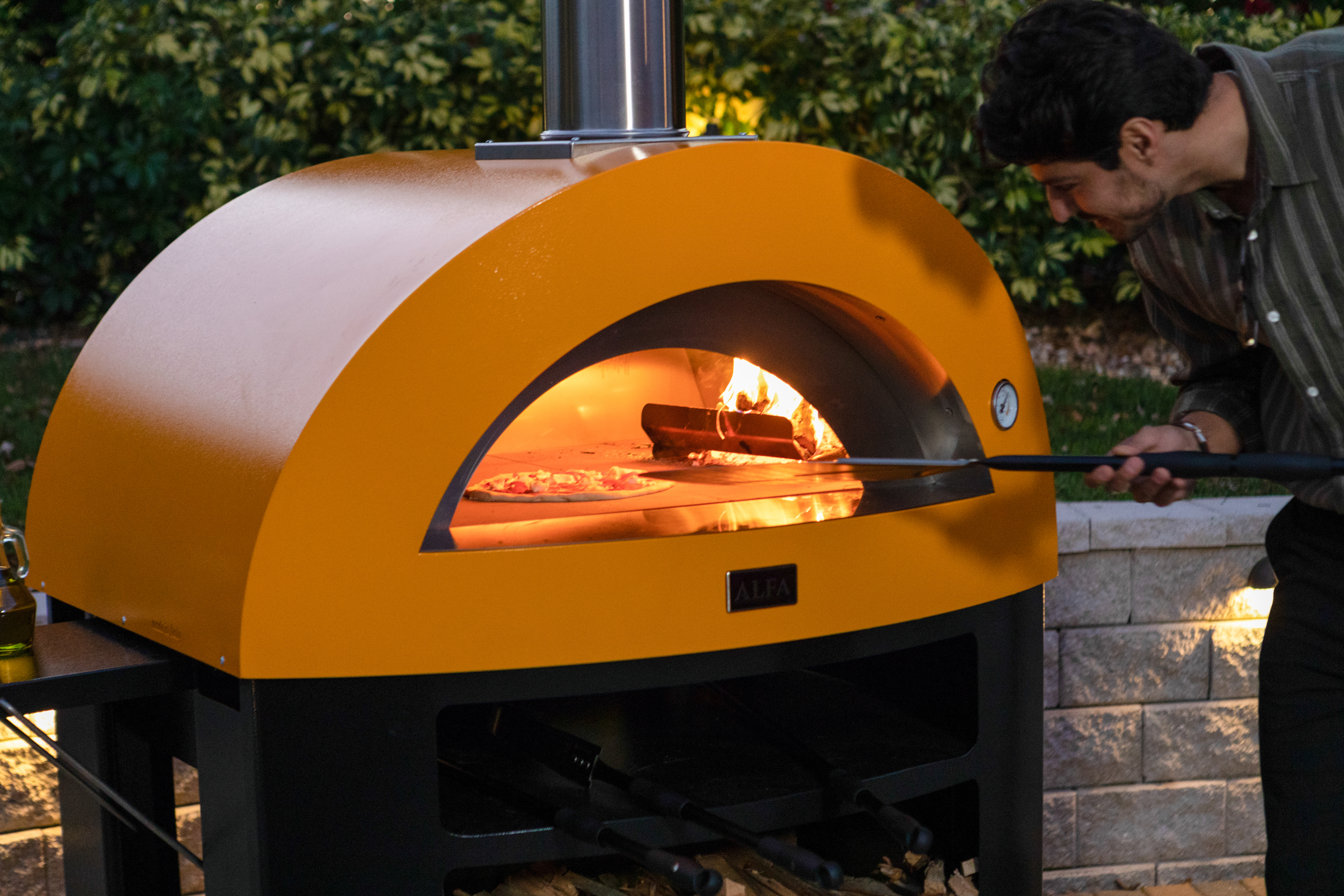 Moderno 5 Pizze oven with wood fire and pizza cooking inside